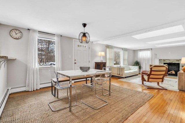 dining space featuring light wood-style flooring and a fireplace