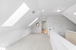 bonus room with lofted ceiling with skylight