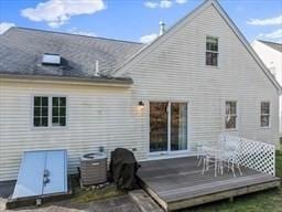 rear view of house with central AC and a deck