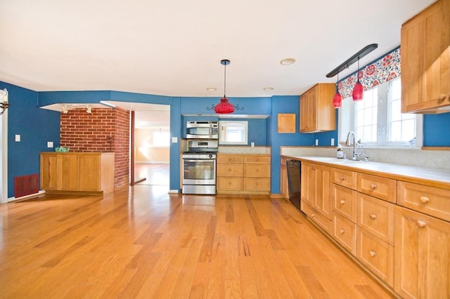 38 Kimball Beach Rd, Hingham, MA 02043 - kitchen featuring appliances with stainless steel finishes, a sink, light countertops, light wood-type flooring, and pendant lighting