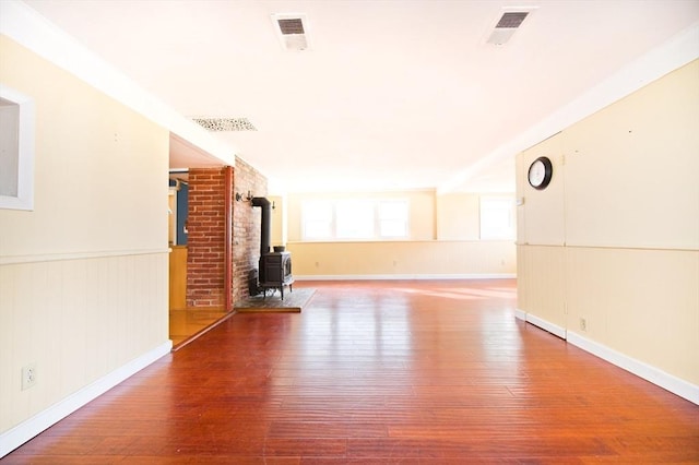 38 Kimball Beach Rd, Hingham, MA 02043 - unfurnished living room with a wood stove, wood-type flooring, wainscoting, and baseboards