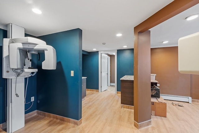 interior space with light wood finished floors, a baseboard radiator, and baseboards