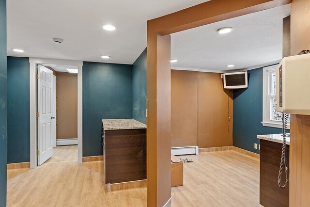 interior space featuring a baseboard heating unit, recessed lighting, baseboards, and wood finished floors