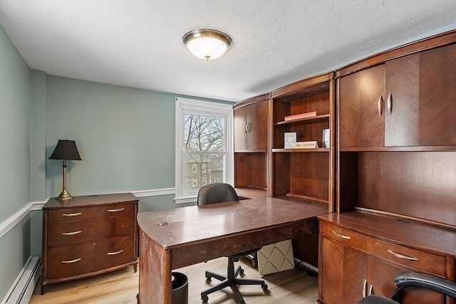 office area with light wood-style floors and a baseboard heating unit