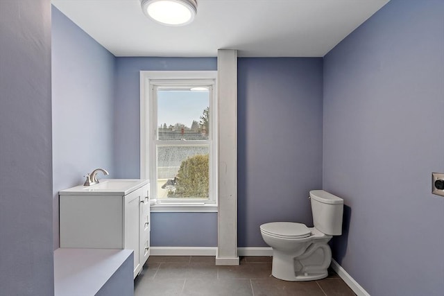 bathroom featuring tile patterned flooring, toilet, vanity, and baseboards