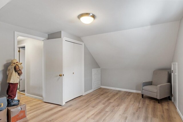 bonus room featuring lofted ceiling, light wood-style flooring, and baseboards
