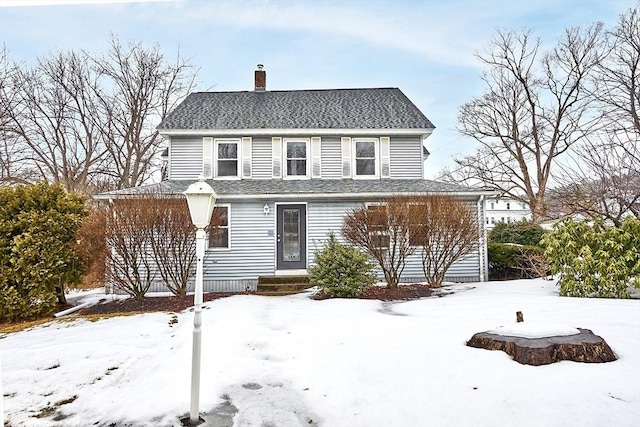view of front of property with roof with shingles and a chimney