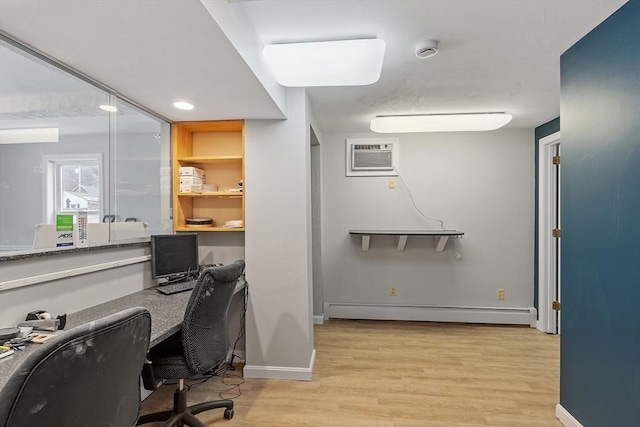 office area featuring a baseboard heating unit, light wood finished floors, a wall unit AC, and baseboards