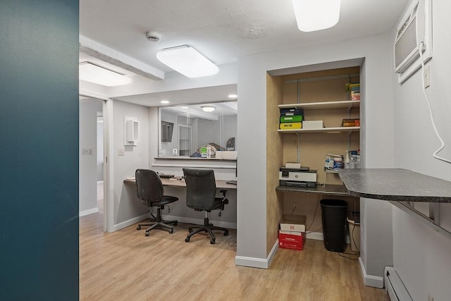 office featuring baseboard heating, wood finished floors, built in study area, and baseboards