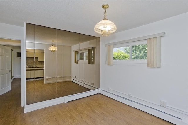 83 Horseshoe Dr Unit 83, Chicopee, MA 01022 - empty room with a chandelier, wood finished floors, and baseboard heating