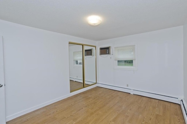 83 Horseshoe Dr Unit 83, Chicopee, MA 01022 - unfurnished room with light wood-type flooring, a wall mounted AC, a baseboard heating unit, and a baseboard radiator