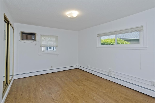 83 Horseshoe Dr Unit 83, Chicopee, MA 01022 - unfurnished room featuring a wall mounted AC, a baseboard radiator, and wood finished floors
