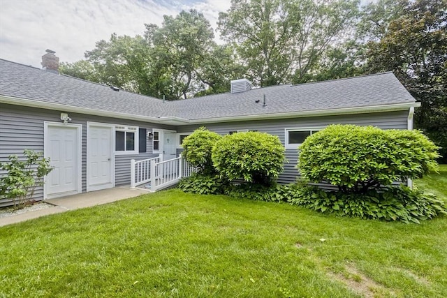83 Horseshoe Dr Unit 83, Chicopee, MA 01022 - back of house with a chimney, a lawn, and roof with shingles