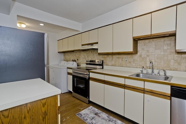 83 Horseshoe Dr Unit 83, Chicopee, MA 01022 - kitchen with stainless steel appliances, washing machine and dryer, light countertops, tasteful backsplash, and under cabinet range hood