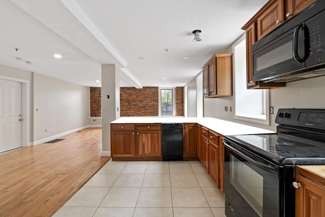 72 River St Unit 2, Haverhill, MA 01832 - kitchen with black appliances, brown cabinets, a peninsula, light countertops, and recessed lighting