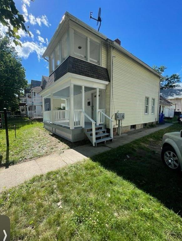 rear view of property featuring covered porch and roof with shingles