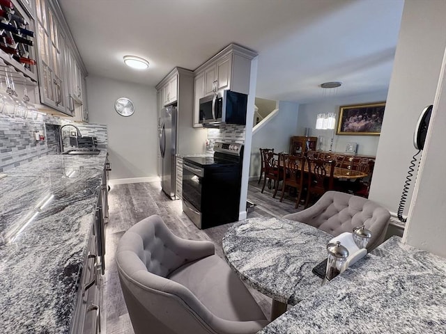 20 Meadowbrook Ln Unit 20, Palmer, MA 01069 - kitchen with appliances with stainless steel finishes, decorative backsplash, a fireplace, wood finished floors, and gray cabinetry