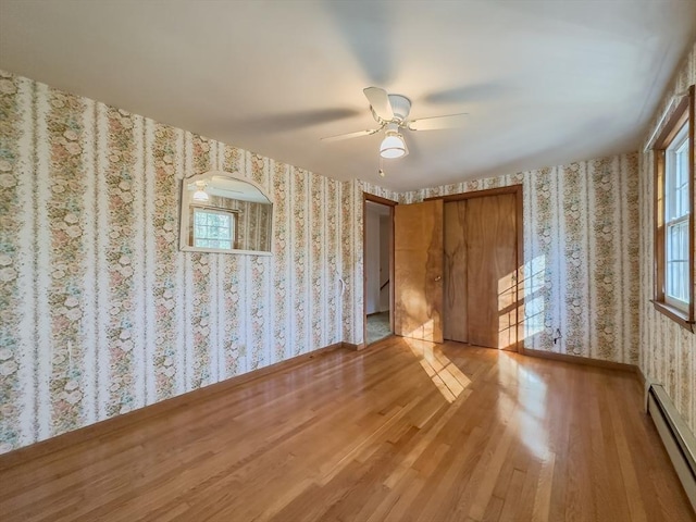 interior space with ceiling fan, light wood-type flooring, and a baseboard radiator