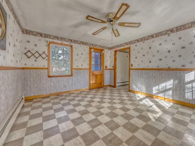 unfurnished room featuring ceiling fan and a baseboard heating unit