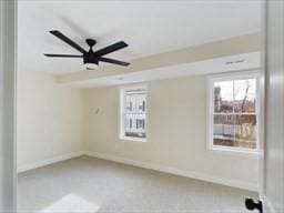 empty room featuring ceiling fan and carpet