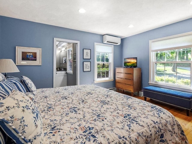 71 Nourse St, Westborough, MA 01581 - bedroom featuring a wall unit AC, multiple windows, wood finished floors, recessed lighting, and ensuite bathroom
