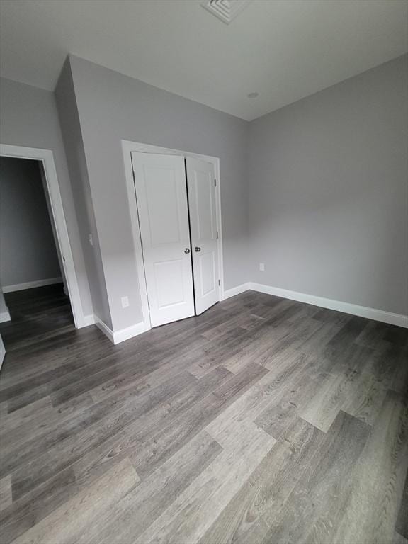 314-316 Dartmouth St, New Bedford, MA 02740 - unfurnished bedroom featuring baseboards, dark wood-style floors, and a closet