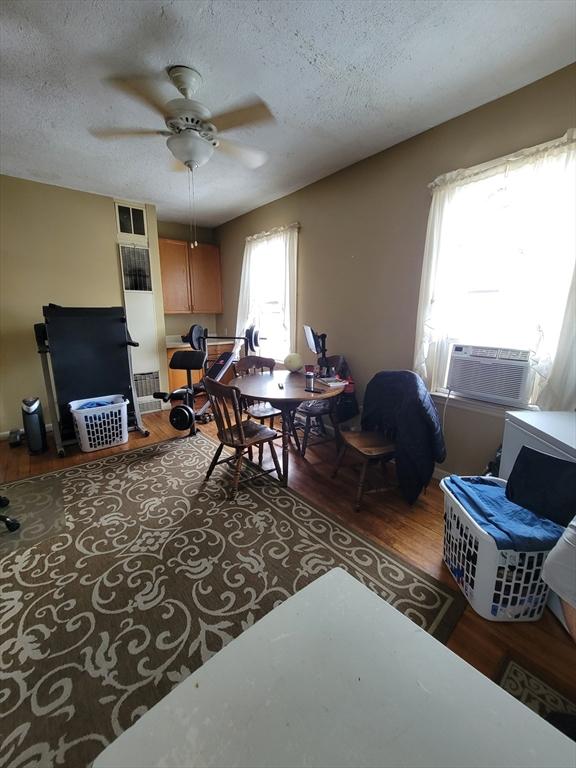 314-316 Dartmouth St, New Bedford, MA 02740 - living area with wood finished floors, a textured ceiling, and a ceiling fan