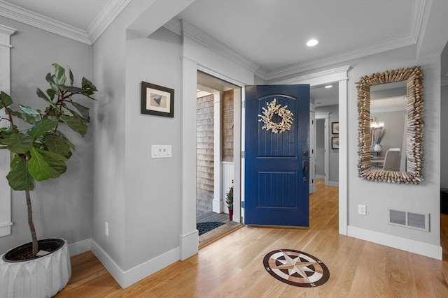 foyer entrance with ornamental molding and wood-type flooring