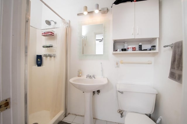 bathroom featuring a shower stall, toilet, and tile patterned floors