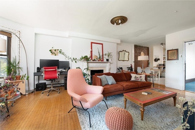 living room featuring a fireplace, an office area, and light wood-style flooring