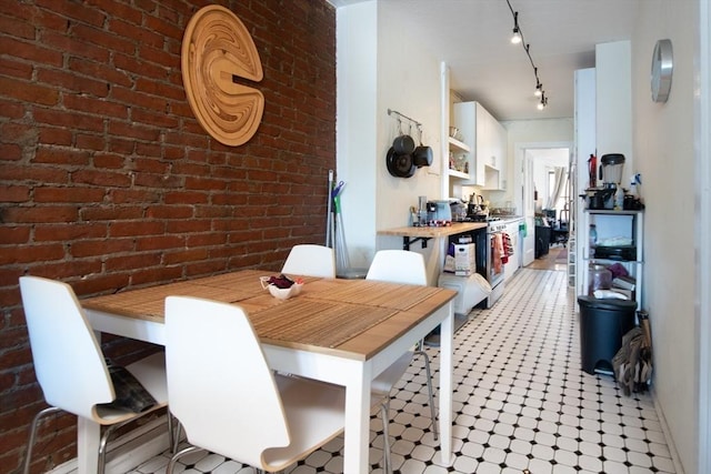 dining area with brick wall and track lighting