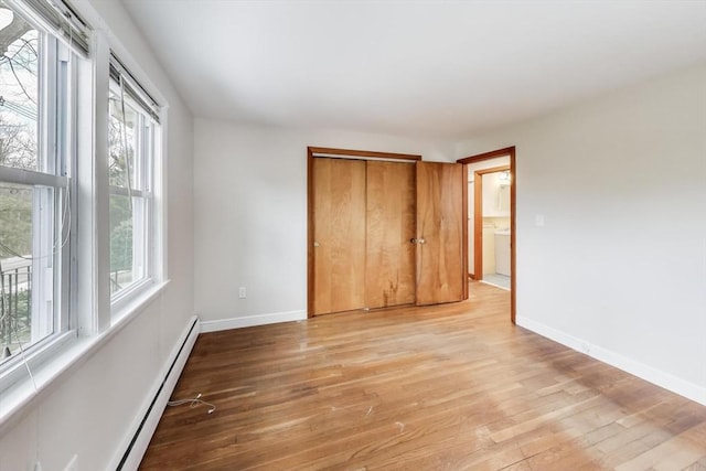 unfurnished bedroom with a closet, light wood-type flooring, and baseboards