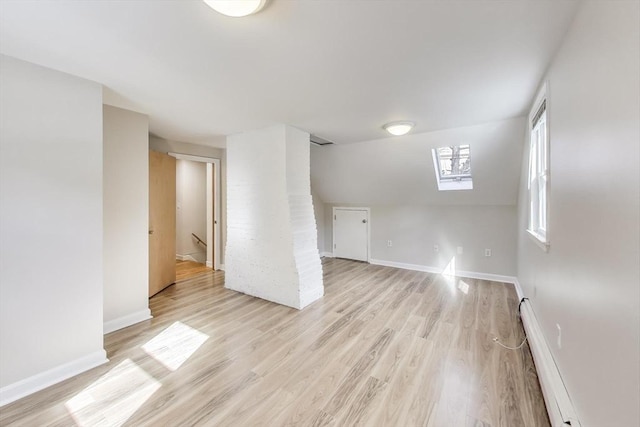 spare room featuring baseboards, a baseboard radiator, and light wood-style floors