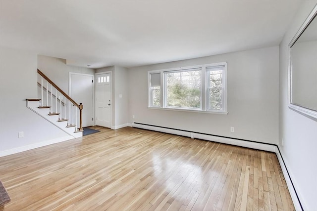 interior space featuring baseboards, stairway, baseboard heating, and hardwood / wood-style floors