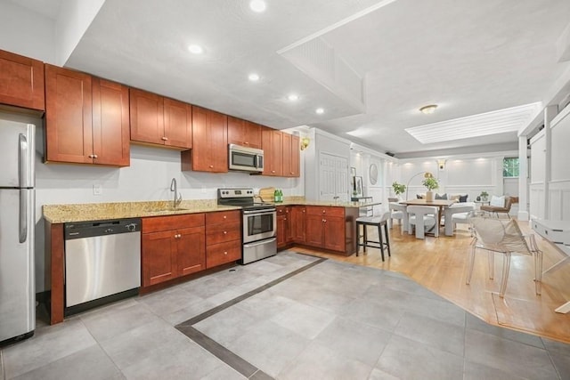 515 Franklin St Unit 4, Cambridge, MA 02139 - kitchen featuring stainless steel appliances, a sink, recessed lighting, light stone counters, and a peninsula