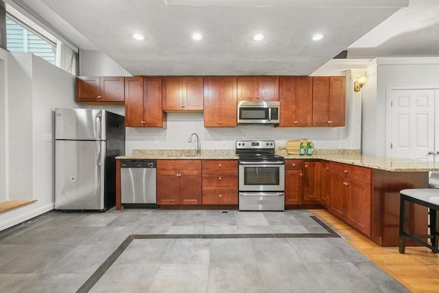 515 Franklin St Unit 4, Cambridge, MA 02139 - kitchen featuring appliances with stainless steel finishes, a peninsula, recessed lighting, light stone countertops, and a sink