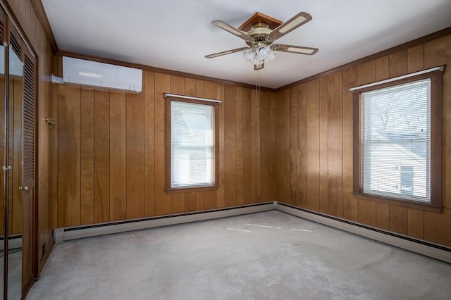 spare room featuring plenty of natural light, an AC wall unit, carpet, and a ceiling fan