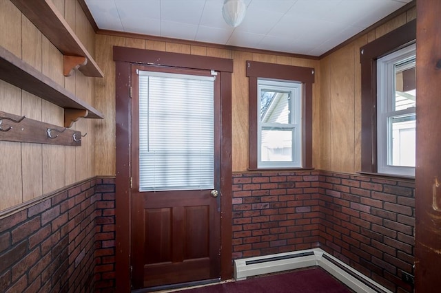 doorway with wooden walls, brick wall, and a baseboard heating unit