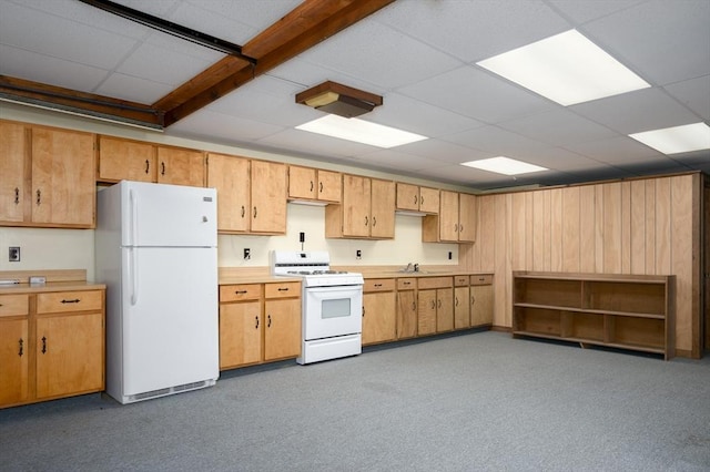 kitchen with a drop ceiling, white appliances, light countertops, and a sink