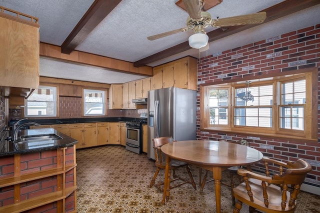 kitchen with a sink, dark countertops, brick wall, and stainless steel appliances