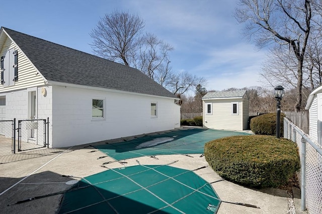 view of swimming pool with a fenced in pool, fence, an outdoor structure, a patio area, and a gate