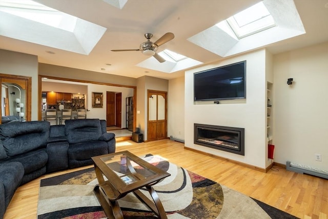4 Fall St, Malden, MA 02148 - living area featuring a skylight, light wood-type flooring, ceiling fan, and a glass covered fireplace