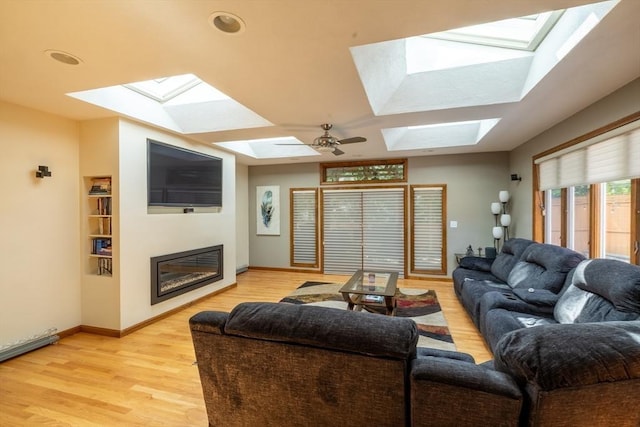 4 Fall St, Malden, MA 02148 - living room featuring a skylight, a glass covered fireplace, baseboards, and light wood-type flooring