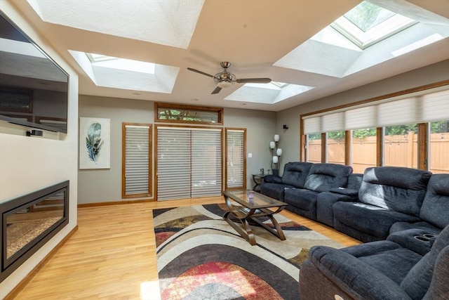 4 Fall St, Malden, MA 02148 - living area with a skylight, wood finished floors, baseboards, and ceiling fan
