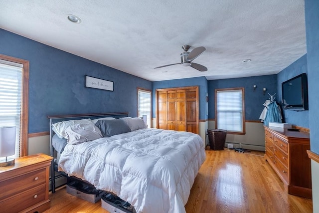 4 Fall St, Malden, MA 02148 - bedroom featuring a baseboard radiator, multiple windows, light wood-type flooring, a closet, and a textured ceiling