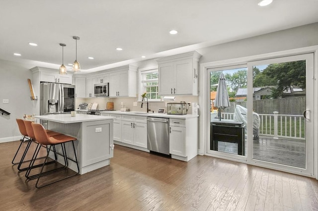116 Pilgrim Rd Unit 116, Haverhill, MA 01832 - kitchen with stainless steel appliances, a breakfast bar area, dark wood-style flooring, light countertops, and recessed lighting