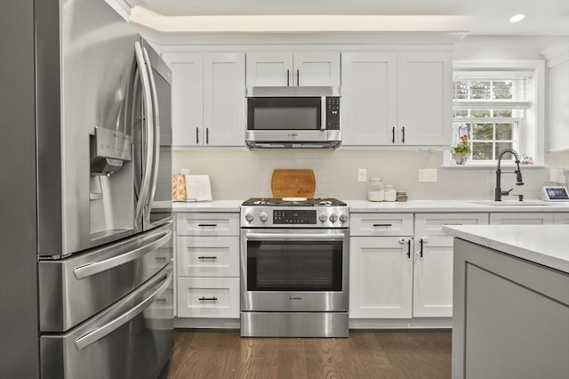 116 Pilgrim Rd Unit 116, Haverhill, MA 01832 - kitchen with appliances with stainless steel finishes, light countertops, decorative backsplash, dark wood-style floors, and white cabinetry