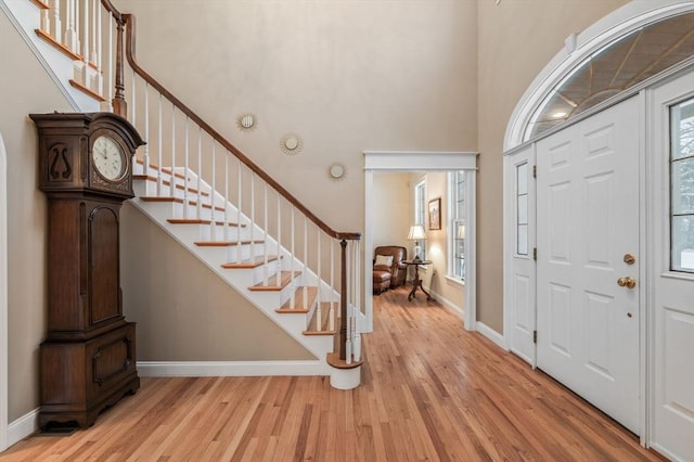 foyer featuring a towering ceiling and light hardwood / wood-style floors