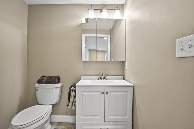 bathroom with vanity, toilet, and baseboards