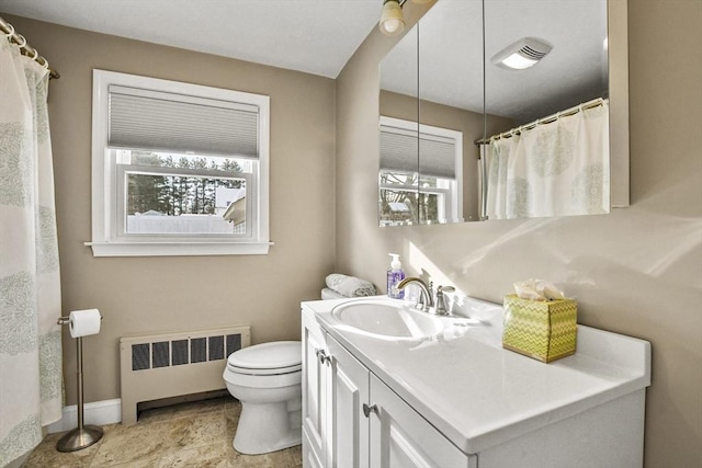 bathroom featuring visible vents, baseboards, toilet, radiator heating unit, and vanity